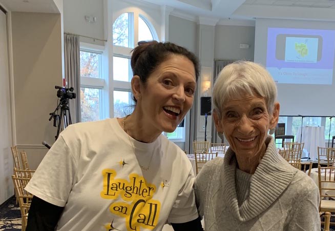 Senior and caregiver smiling together in a warm care setting